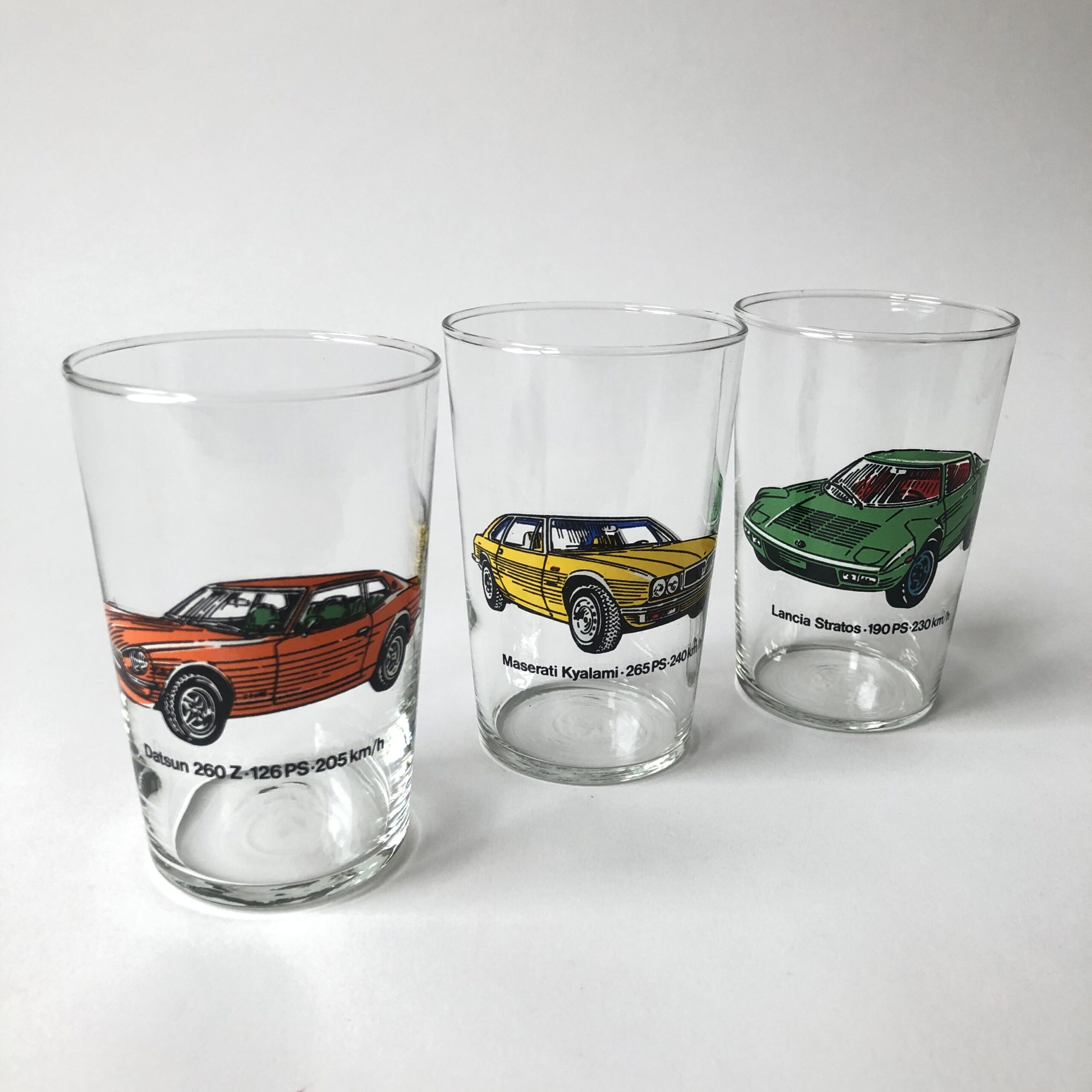 Vintage glazen met afbeeldingen van auto’s, Datsun 260 Z, Maserati Kyalami 265 PS en Lancia Stratos 190 PS